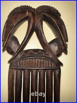 Art Africain, ancien peigne en bois finement sculpté figurant deux masques