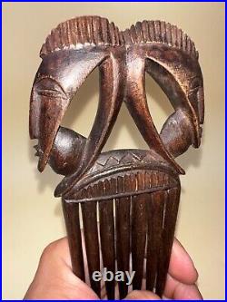 Art Africain, ancien peigne en bois finement sculpté figurant deux masques