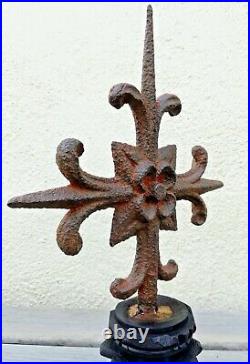 Croix très ancienne à la fleur de lys en fer forgé sur socle en bois sculpté
