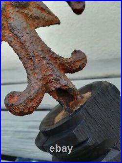 Croix très ancienne à la fleur de lys en fer forgé sur socle en bois sculpté