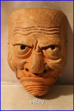 Masque ancien en bois sculpté au visage grimaçant Japon