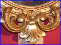 Miroir ancien de forme ovale en bois sculpté et doré tout début XIXe (1810-1830)