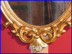 Miroir ancien de forme ovale en bois sculpté et doré tout début XIXe (1810-1830)
